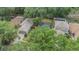 An aerial view displays property in a lush, established neighborhood with mature trees and a screened in pool at 1524 Marsh Wood Dr, Seffner, FL 33584