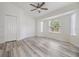 Bright, airy bedroom featuring sleek wood-look flooring and a modern ceiling fan at 1524 Marsh Wood Dr, Seffner, FL 33584