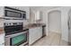 Well-lit kitchen features stainless steel appliances, white cabinets and tile floors at 1524 Marsh Wood Dr, Seffner, FL 33584