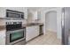 This kitchen features stainless steel appliances, white cabinets and tile floors at 1524 Marsh Wood Dr, Seffner, FL 33584
