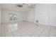 A bright living room featuring tile flooring, ceiling fan, and a front door at 1524 Marsh Wood Dr, Seffner, FL 33584