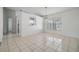 This is a bright dining area with a view to the kitchen and a modern light fixture at 1524 Marsh Wood Dr, Seffner, FL 33584