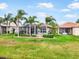 Expansive backyard with lush green lawn, mature trees, and a screened lanai at 15707 Crystal Waters Dr, Wimauma, FL 33598