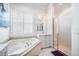 Bright bathroom featuring a corner tub and a glass-enclosed shower at 15707 Crystal Waters Dr, Wimauma, FL 33598