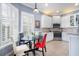 Cozy kitchen nook featuring white cabinets, stainless appliances, tile backsplash and shuttered windows at 15707 Crystal Waters Dr, Wimauma, FL 33598