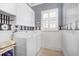 Well-organized laundry room with white appliances and fun decorative wallpaper at 15707 Crystal Waters Dr, Wimauma, FL 33598