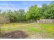 Spacious backyard featuring a tranquil pond view, a fire pit, and a partially fenced area at 16116 Manorwood Cir, Tampa, FL 33624