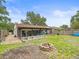 Charming backyard with a brick fire pit, screened porch, grassy area, and patio at 16116 Manorwood Cir, Tampa, FL 33624