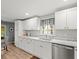 Bright kitchen featuring white cabinets, marble countertops, and natural light at 16116 Manorwood Cir, Tampa, FL 33624