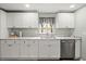 Modern kitchen with white cabinets, stainless steel dishwasher, and marble countertops at 16116 Manorwood Cir, Tampa, FL 33624