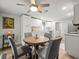 Eat-in kitchen featuring a wooden table, modern ceiling fan and white cabinets at 16116 Manorwood Cir, Tampa, FL 33624