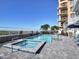 Inviting community pool and hot tub with poolside lounge chairs and ocean views in a modern building at 19816 Gulf Blvd # 602, Indian Shores, FL 33785