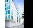 Modern white building featuring impact windows, ground level garage, and a partial view of a palm tree at 19816 Gulf Blvd # 602, Indian Shores, FL 33785