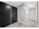 Well lit hallway featuring modern gray flooring, dark doors, and white doors leading to different areas at 19816 Gulf Blvd # 602, Indian Shores, FL 33785