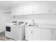 Clean and modern laundry room with white cabinets, sink, and new washer and dryer at 19816 Gulf Blvd # 602, Indian Shores, FL 33785