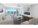 Bright living room with views of the ocean, electric fireplace and white brick accent wall at 19816 Gulf Blvd # 602, Indian Shores, FL 33785
