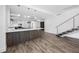 Open-concept living space with a modern kitchen island and floating staircase at 19816 Gulf Blvd # 602, Indian Shores, FL 33785