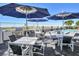 Outdoor dining and lounge area next to the community pool with patio umbrellas and ocean views at 19816 Gulf Blvd # 602, Indian Shores, FL 33785