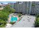 Aerial view showcases pool, patio, building, surrounding trees, and downtown skyline in the distance at 201 W Laurel St # 307, Tampa, FL 33602