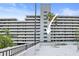 Exterior view from roof deck shows high rise waterfront condo with palm trees and lounge seating at 201 W Laurel St # 307, Tampa, FL 33602