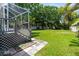 Backyard features a well-maintained lawn and a screened lanai for outdoor living at 209 Arlington E Ave, Oldsmar, FL 34677