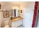 Bathroom featuring a single sink vanity and a white door, complemented by beige granite countertop at 209 Arlington E Ave, Oldsmar, FL 34677