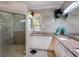 Elegant bathroom with granite countertops, dual sinks, a glass-enclosed shower, and neutral tile at 209 Arlington E Ave, Oldsmar, FL 34677