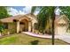 Charming single-Gathering home featuring a well-manicured lawn, a red brick walkway, and a tan exterior at 209 Arlington E Ave, Oldsmar, FL 34677