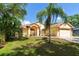 Charming single-story home with a well-manicured lawn and lush landscaping at 209 Arlington E Ave, Oldsmar, FL 34677