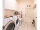 Bright laundry room featuring tile floors, appliances, and extra storage at 209 Arlington E Ave, Oldsmar, FL 34677
