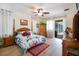 Airy main bedroom with wood floors, ceiling fan, slider to lanai, and stylish tropical bedding at 209 Arlington E Ave, Oldsmar, FL 34677