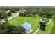 A sunny aerial view shows a green neighborhood park with walking paths and a blue pyramid at 209 Arlington E Ave, Oldsmar, FL 34677