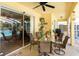 Covered patio with ceiling fan and table setting provides comfortable outdoor space, adjacent to the screened-in pool area at 209 Arlington E Ave, Oldsmar, FL 34677
