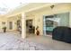 Covered patio with tile flooring, a grill, ceiling fan, and sliding doors to the pool at 209 Arlington E Ave, Oldsmar, FL 34677