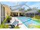 Relaxing screened-in pool area with outdoor seating, a chaise lounge, and clear blue water at 209 Arlington E Ave, Oldsmar, FL 34677
