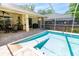 Enclosed swimming pool with tile surround and seating areas on patio at 209 Arlington E Ave, Oldsmar, FL 34677