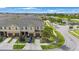 Townhomes with attached garages, lush landscaping, and a serene pond in a well-maintained community from above at 2227 Golden Falcon Dr, Ruskin, FL 33570