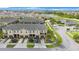 Aerial view of townhomes with attached garages, lush landscaping, and a serene pond in a well-maintained community at 2227 Golden Falcon Dr, Ruskin, FL 33570