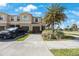 Exterior view of a tan two-story townhome with a front yard and a two-car garage at 2227 Golden Falcon Dr, Ruskin, FL 33570