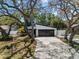 Charming single Gathering home boasts a modern design, a two-car garage, and mature trees at 2257 Lake Dr, Dunedin, FL 34698