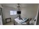 Relaxing bedroom with large window offering a view, ceiling fan, and a comfortable bed with seaside themed décor at 3302 W Shell Point Rd, Ruskin, FL 33570