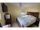 Cozy bedroom features a ceiling fan, a flat-screen TV, and a large bed with a patterned comforter at 3302 W Shell Point Rd, Ruskin, FL 33570