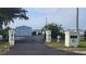 Property entrance featuring a long driveway, steel building, black iron fence and decorative entrance posts at 3302 W Shell Point Rd, Ruskin, FL 33570