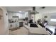 Well-lit kitchen featuring stainless steel appliances, white cabinetry and stone countertops, seamlessly connected to the living room at 3302 W Shell Point Rd, Ruskin, FL 33570