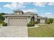 A well-maintained home showcasing an attached garage, brick paver driveway, arched entryway, and neatly manicured landscaping at 336 Northway Dr, Sun City Center, FL 33573