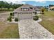 A single-story home featuring a brick paver driveway leading to an attached two-car garage and landscaped front yard at 336 Northway Dr, Sun City Center, FL 33573