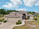Charming single-story home with a neutral color scheme, arched entryway, brick paver driveway, and attached two-car garage at 336 Northway Dr, Sun City Center, FL 33573