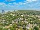 Aerial view of a residential neighborhood with mature trees near a bay, and skyscrapers at 3408 W San Jose St, Tampa, FL 33629