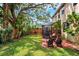 Large backyard with mature trees, a covered brick patio, and a privacy fence at 3408 W San Jose St, Tampa, FL 33629