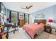Cozy bedroom with a wooden ceiling fan, a desk, and two large windows with blue curtains at 3408 W San Jose St, Tampa, FL 33629